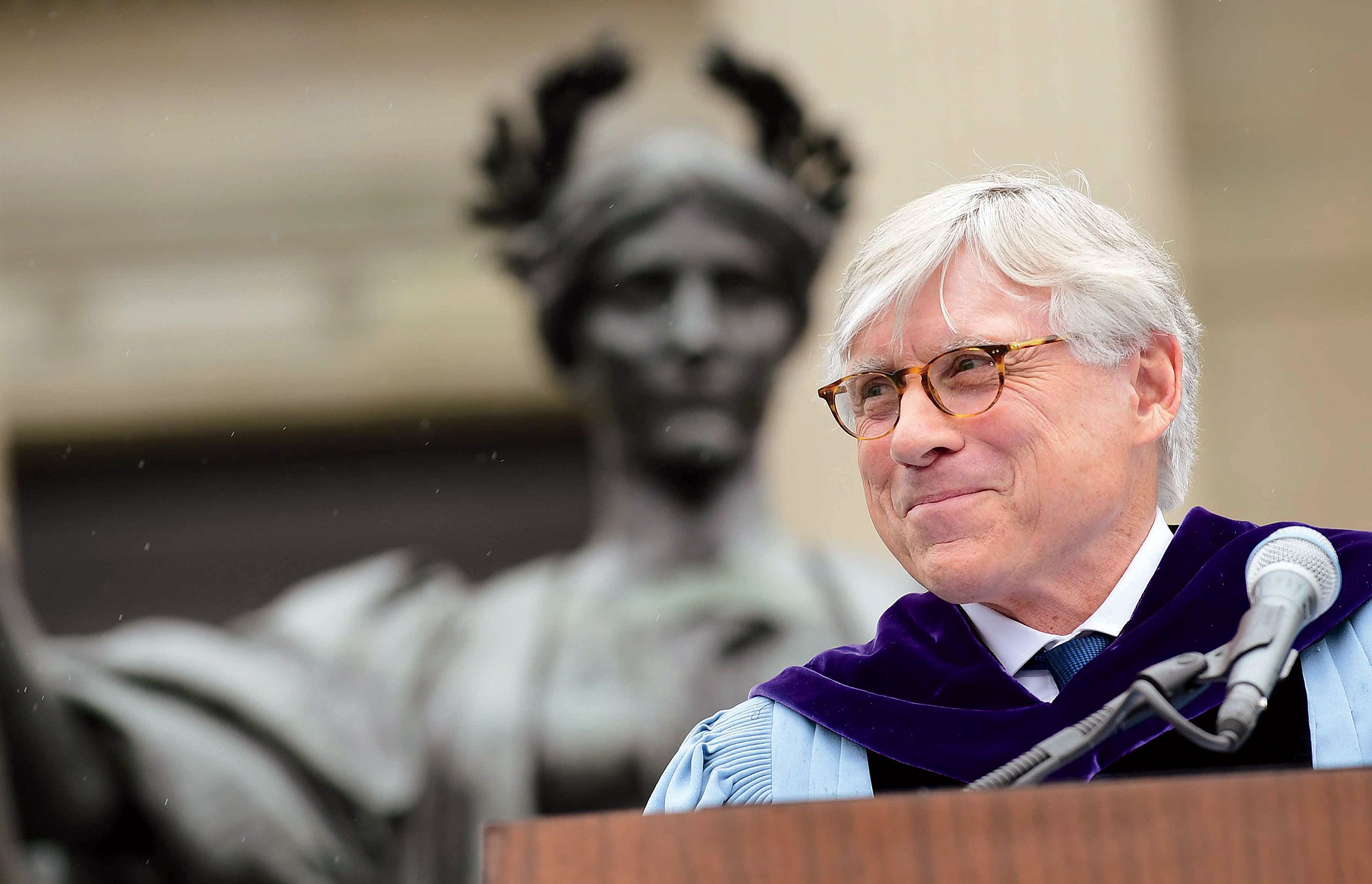 Columbia University president Lee C. Bollinger in front of Alma Mater statue on Low Library steps